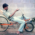 An associate tries out a modified bicycle design built by Ray Wijewardene to improve speed and reduce effort for the rider. Circa 1985.

